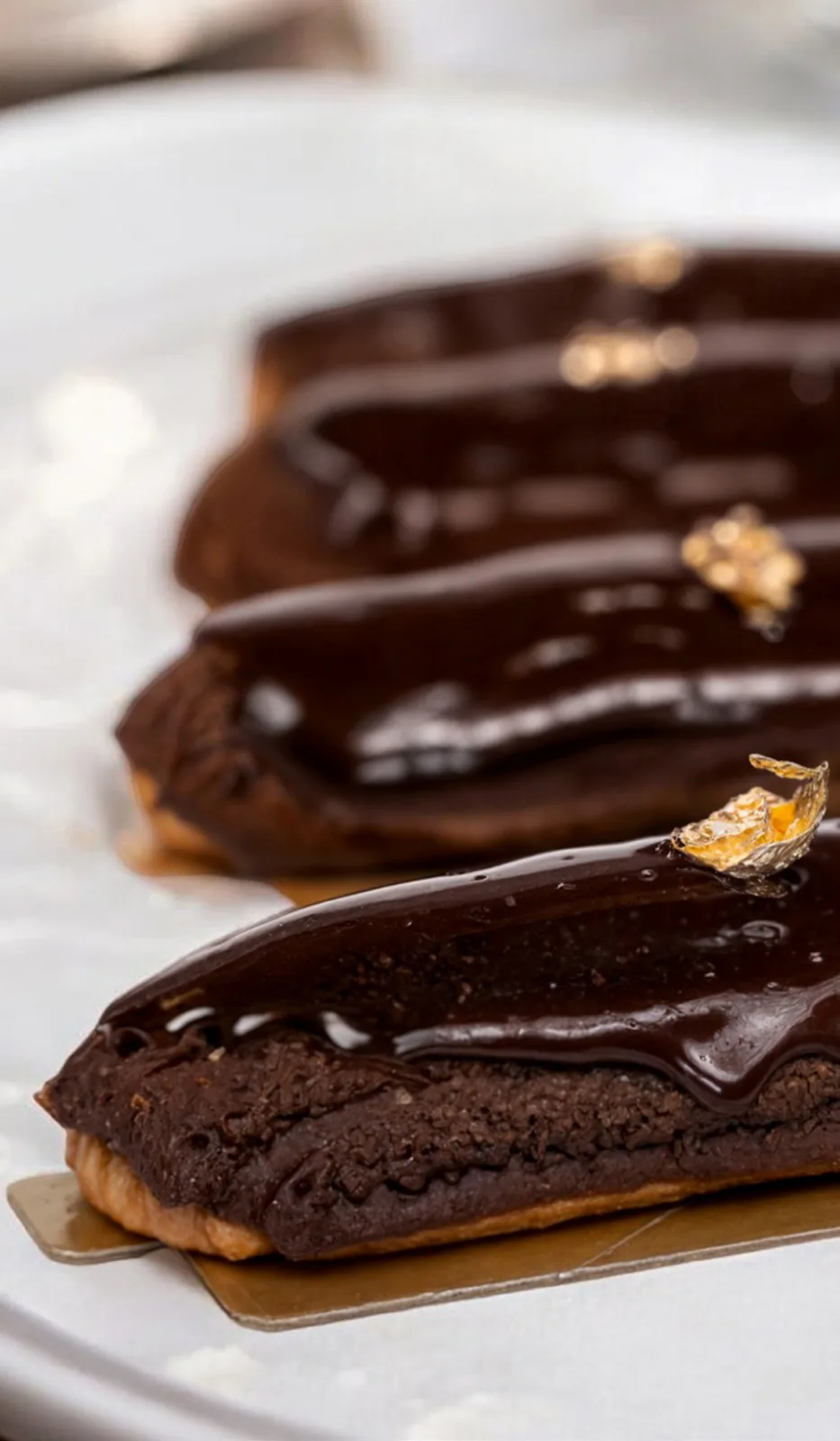 Chocolate éclairs on a dark board