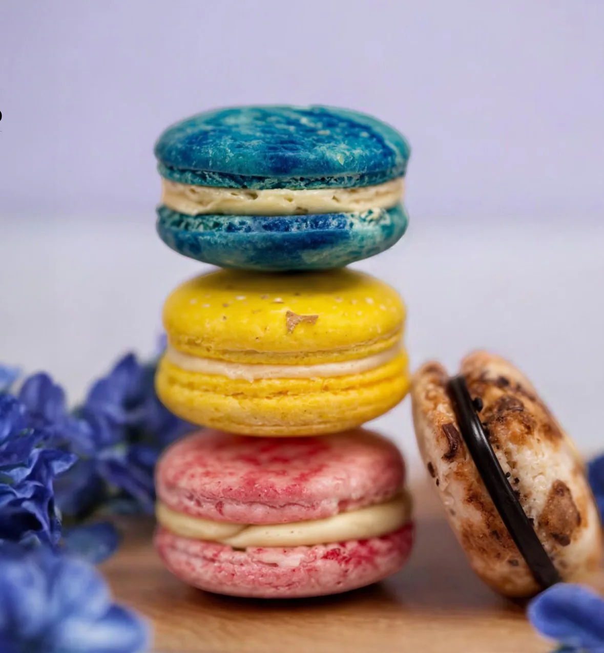 A stack of blue, yellow and pink macarons